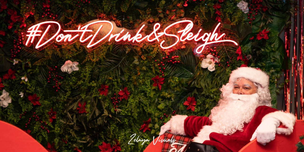 Branded experiential marketing photo moment with neon sign and holiday backdrop